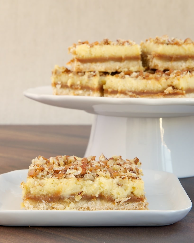 Caramel Cream Cheese Bars feature delicious layers of shortbread, caramel, cream cheese, and nuts. - Bake or Break